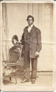 Young Black Man Standing with Hat in Hand