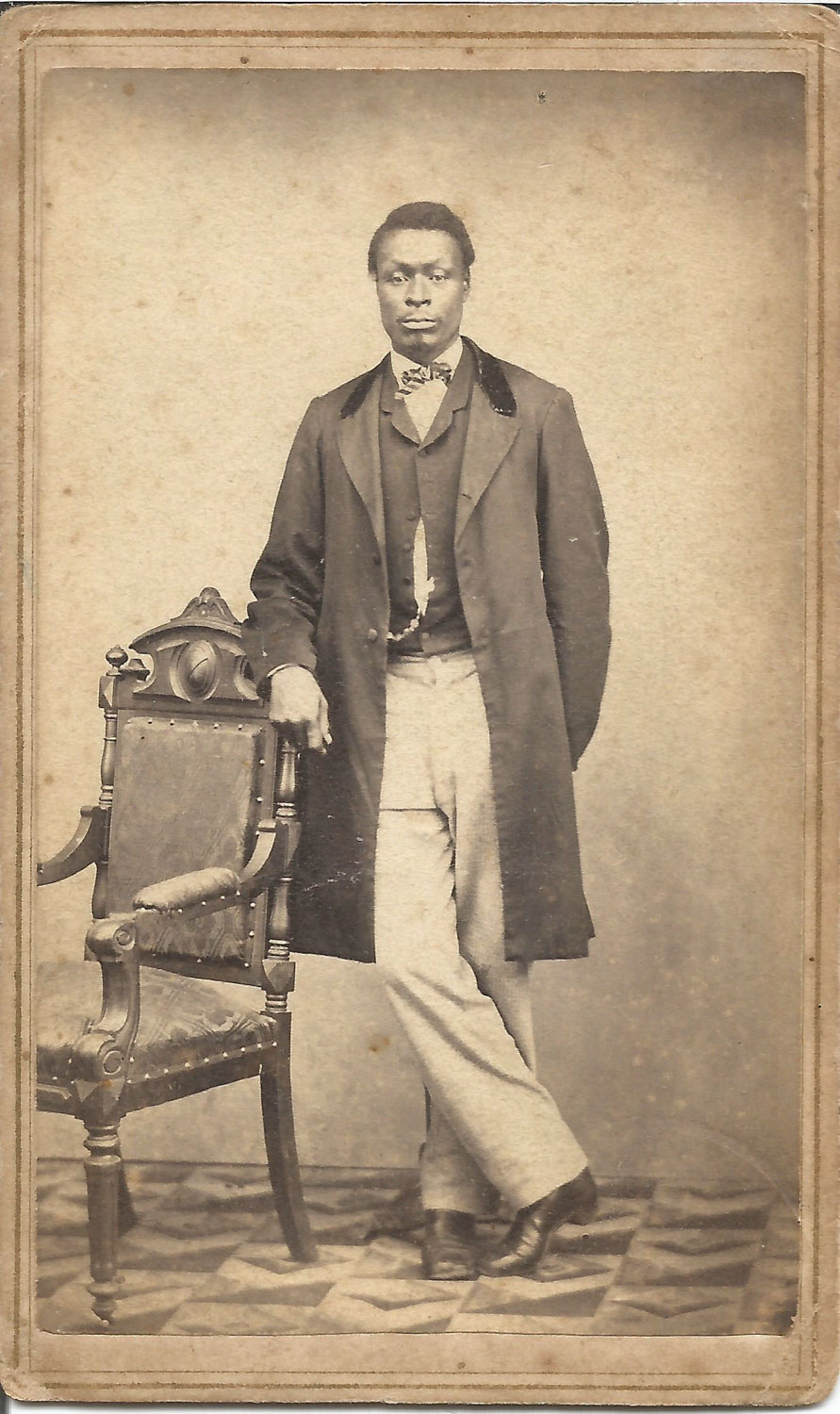 Black Man Standing with Feet Crossed and White Slacks